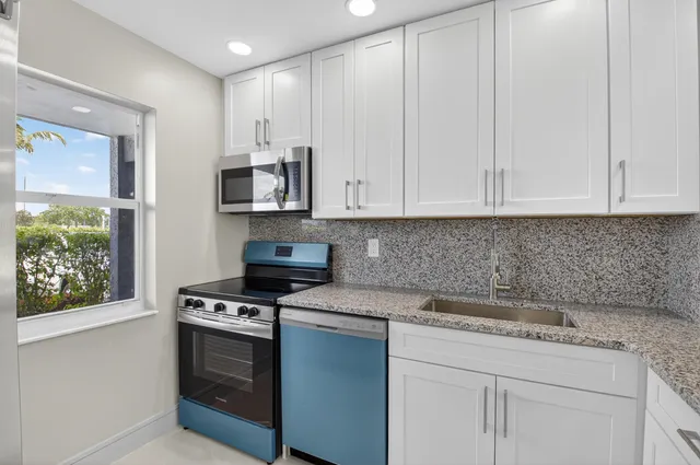 a large room with kitchen view and a window