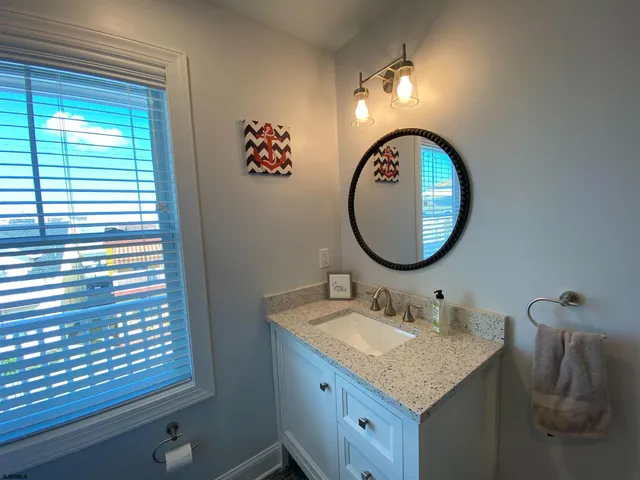 a bathroom with a granite countertop sink and a mirror
