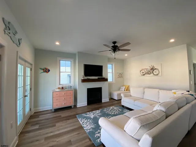 a living room with furniture a flat screen tv and a fireplace