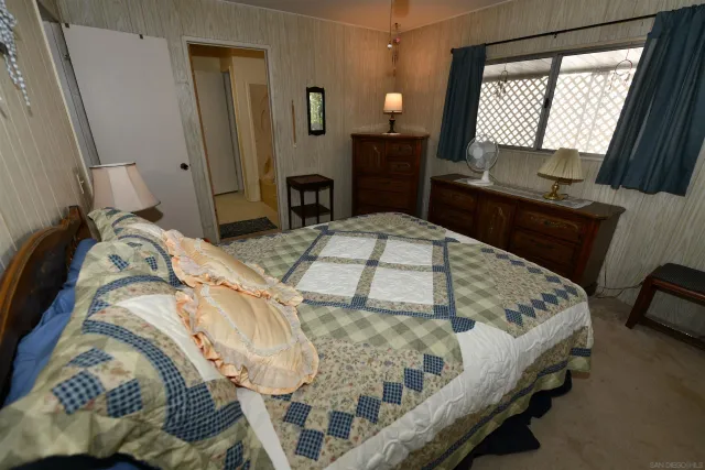 a bed sitting in a bedroom next to a window with tv