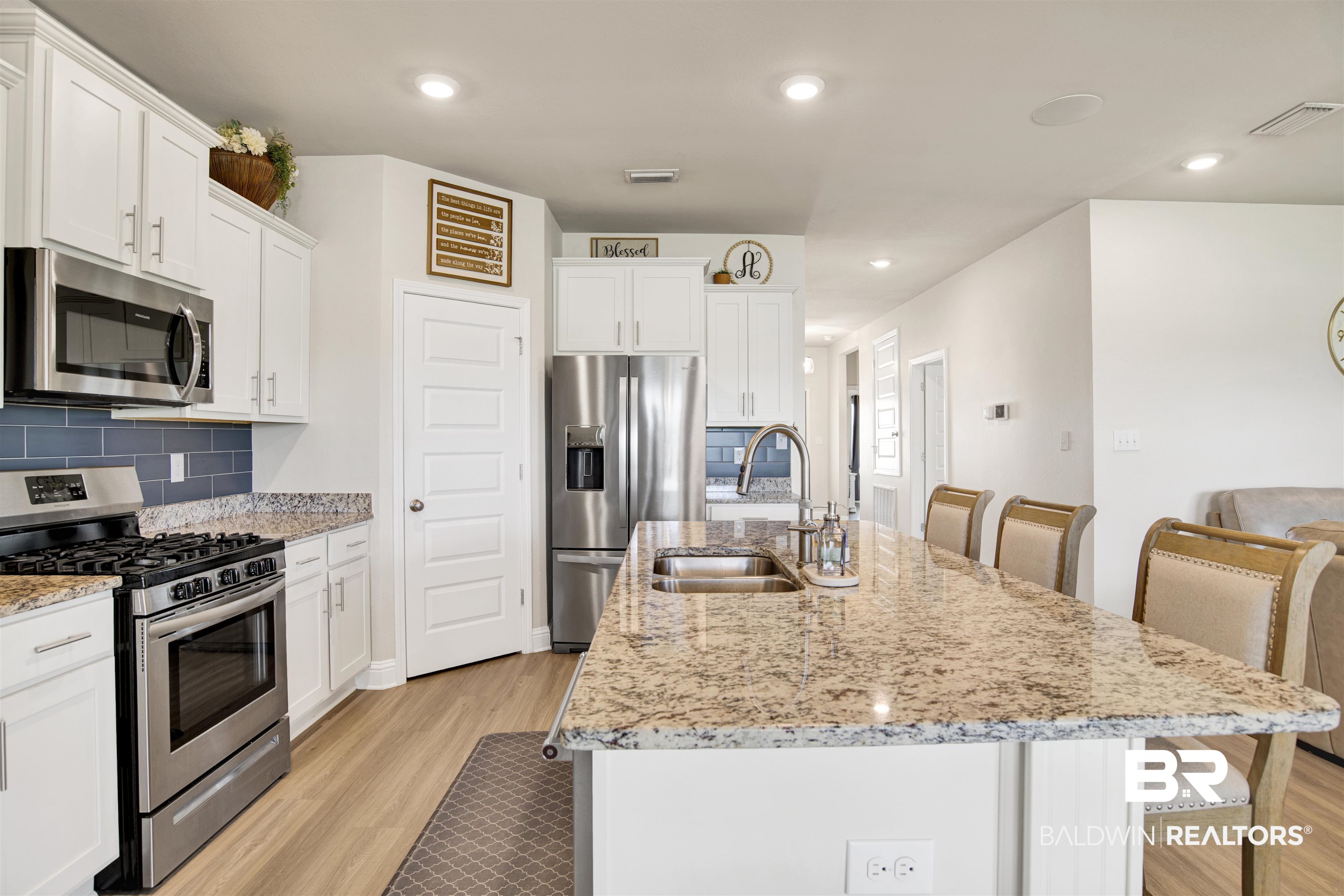 9431 Swan Point Road Daphne, AL 36526 - Photo 11 of 35 Kitchen with appliances with stainless steel finishes, a breakfast bar, light wood-style floors, recessed lighting, and white cabinetry