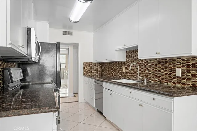 a kitchen with stainless steel appliances granite countertop a sink and cabinets