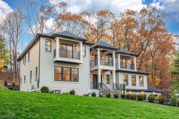 a front view of a house with a yard and trees