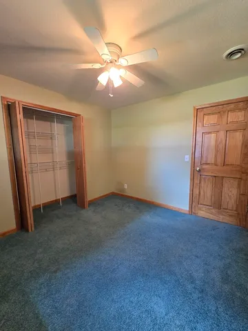 a view of an empty room with a ceiling fan