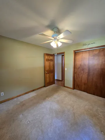 a view of empty room with wooden floor and ceiling fan