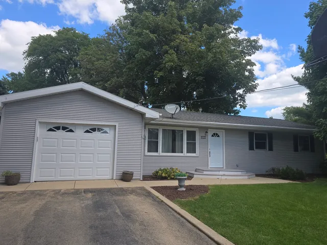 a front view of house with a garden and trees