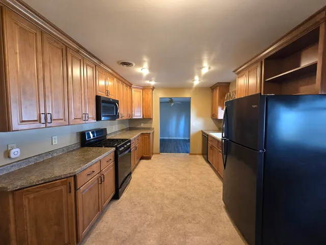 a kitchen with stainless steel appliances granite countertop refrigerator a sink a stove a microwave and island