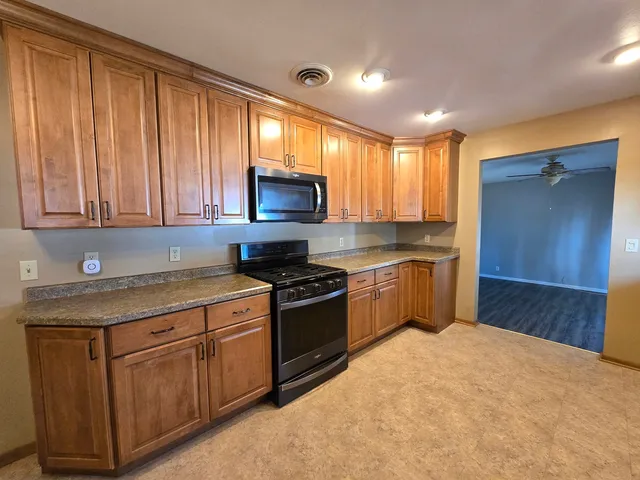a kitchen with stainless steel appliances granite countertop a stove a sink and a refrigerator