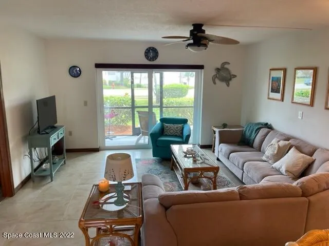 a living room with furniture a flat screen tv and a window