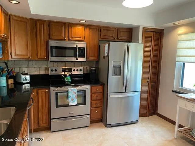 a kitchen with stainless steel appliances granite countertop a refrigerator stove and microwave
