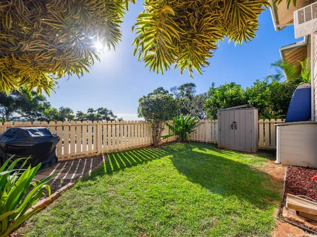 a view of a house with backyard and a tree
