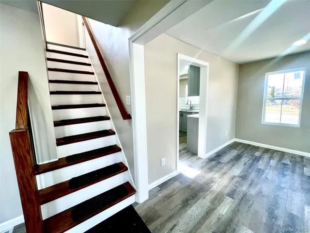 a view of a hallway with wooden floor and windows