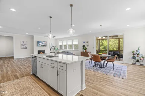 a open kitchen with stainless steel appliances kitchen island granite countertop a sink table and chairs