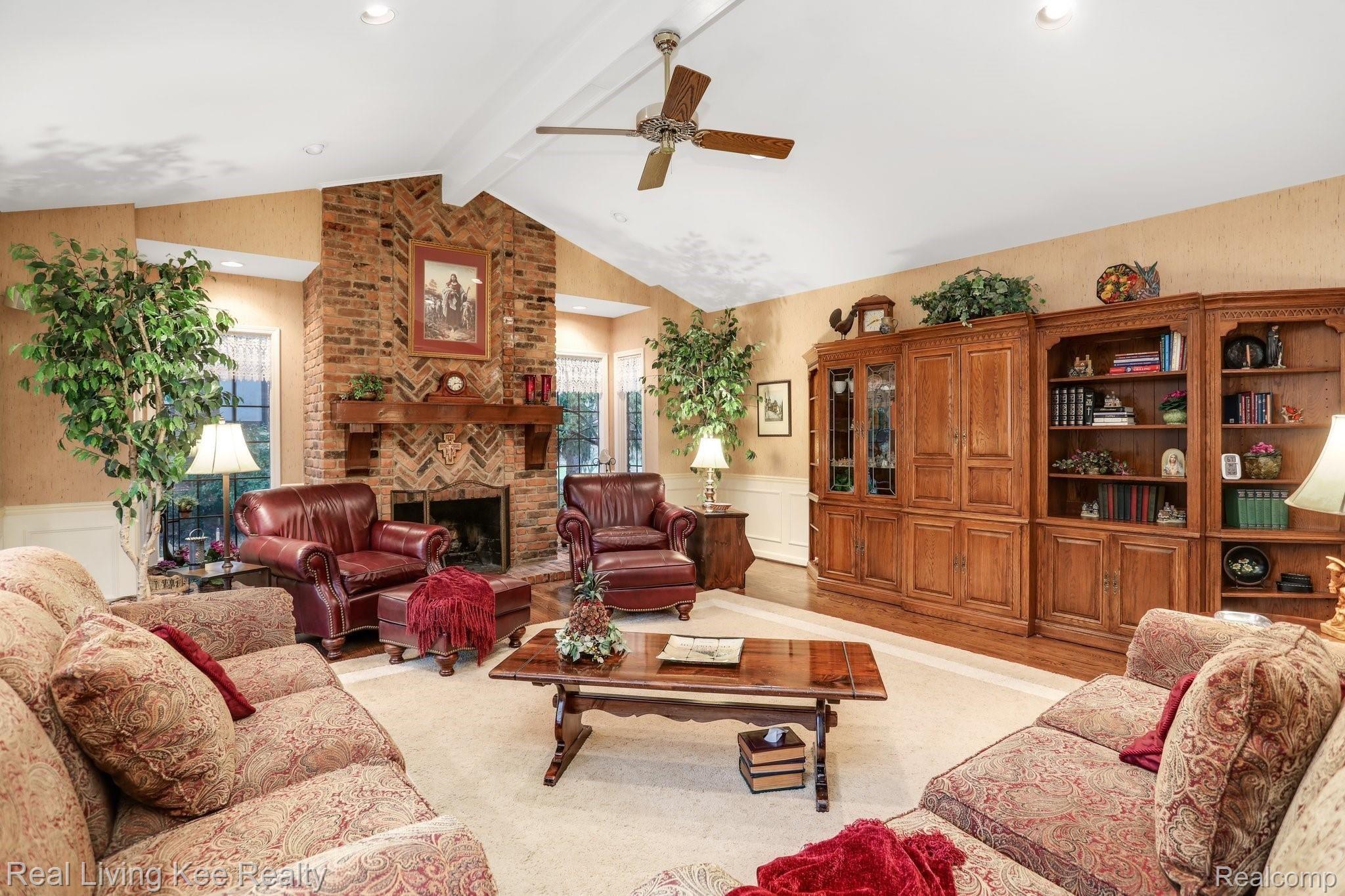 5901 Murfield Drive Rochester, MI 48306 - Photo 27 of 62 Family room view from the kitchen area. Floor to ceiling brick fireplace, surround wainscoting trim. Hardwood flooring.