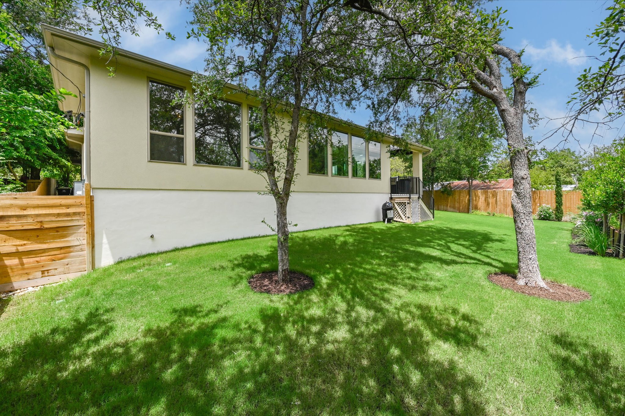913 Presa Arriba Road Austin, TX 78733 - Photo 29 of 30 A verdant backyard with mature trees complements the bright, modern architecture.