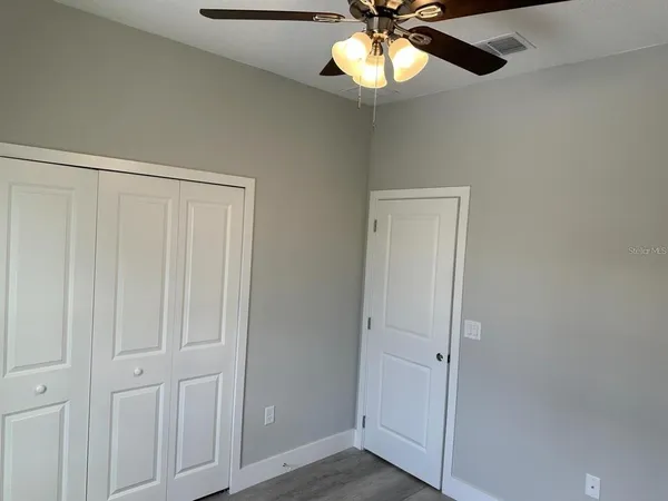 en view of a hallway with a chandelier fan