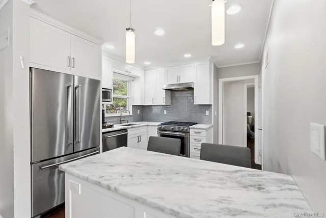 a kitchen with granite countertop a refrigerator oven a sink and dishwasher