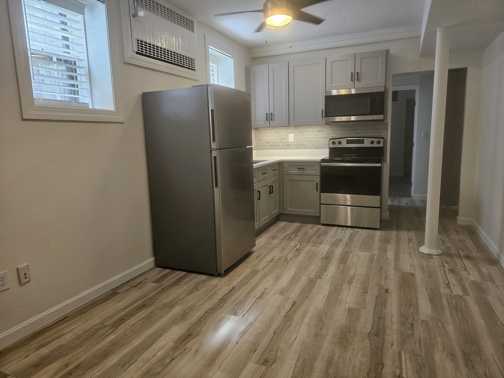 60 Elm Street, Unit 2A Worcester, MA 01609 - Photo 6 of 13 a kitchen with stainless steel appliances a refrigerator and a stove top oven