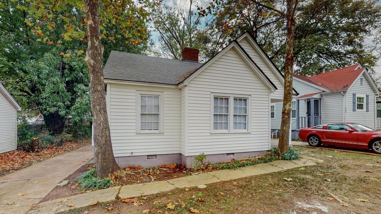 View of front of house featuring crawl space, a chimney, and a shingled roof