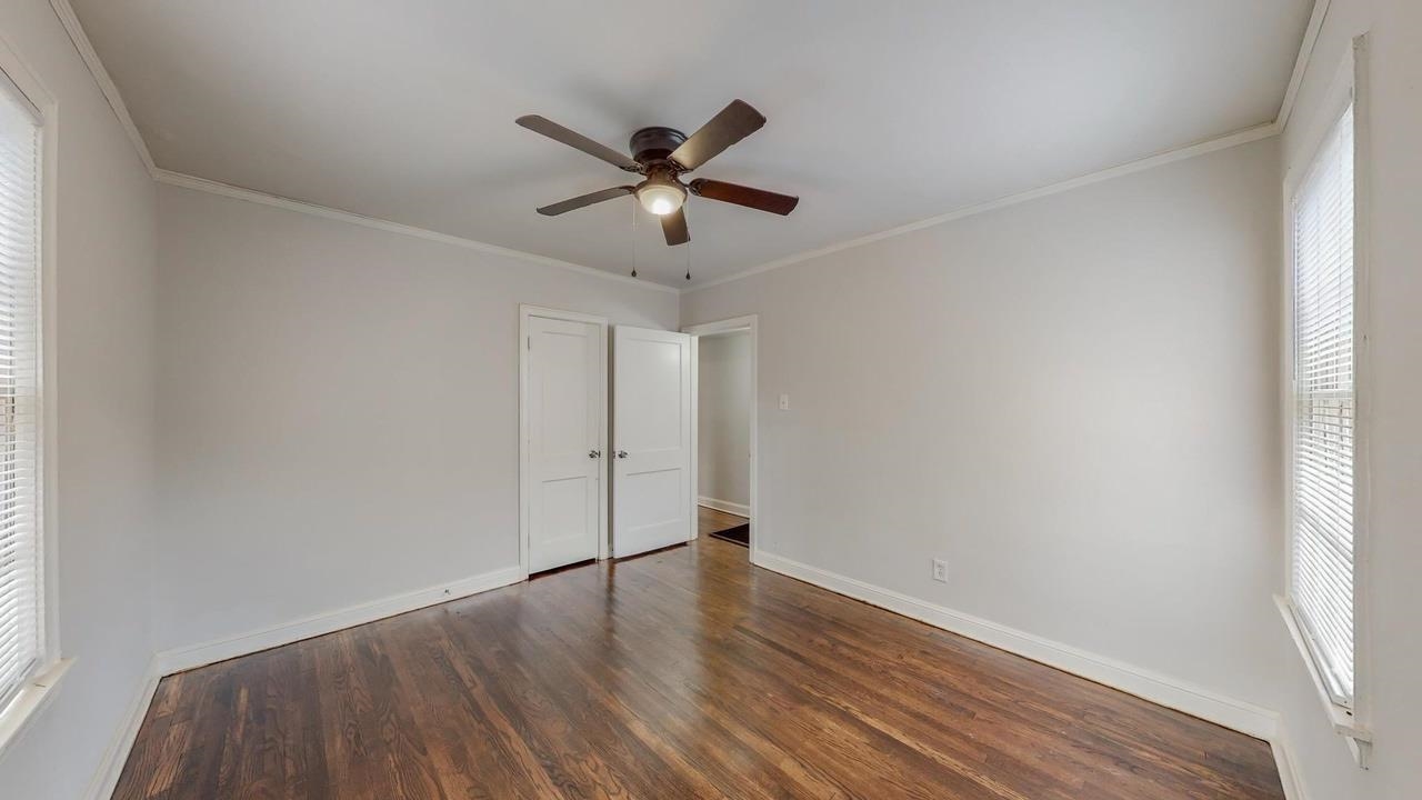 3393 Carrington Road Memphis, TN 38111 - Photo 3 of 11 Unfurnished bedroom featuring multiple windows, crown molding, wood finished floors, and a ceiling fan