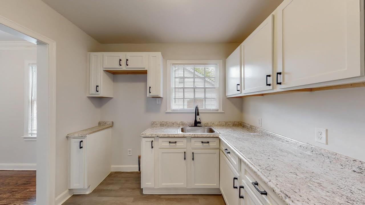 3393 Carrington Road Memphis, TN 38111 - Photo 10 of 11 Kitchen with light wood-type flooring, white cabinetry, and light stone countertops