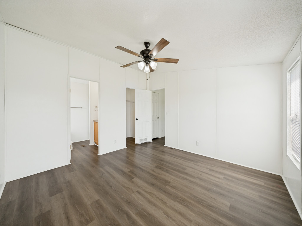 4654 Old Howard Road Temple, TX 76504 - Photo 13 of 25 A generous primary bedroom with warm wood-look flooring and a functional ceiling fan awaits your personal touches.