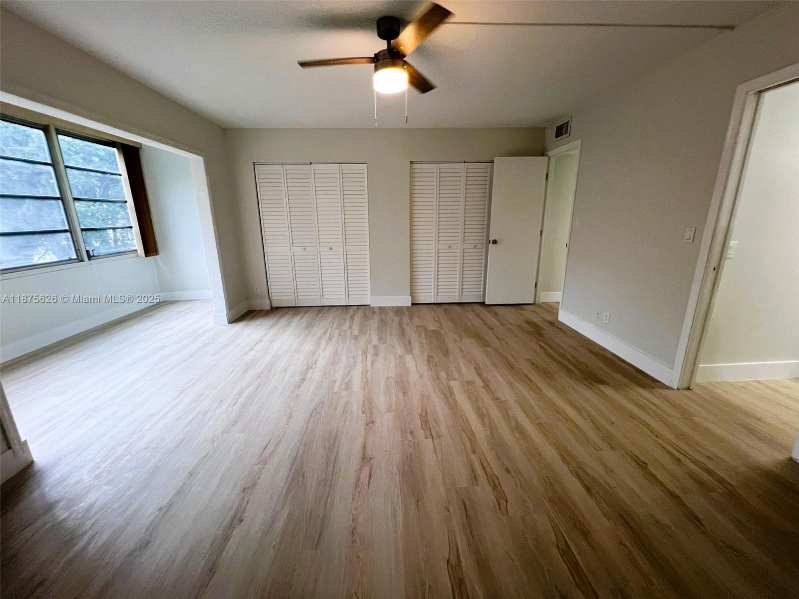 2002 Granada Drive, Unit J3 Coconut Creek, FL 33066 - Photo 12 of 24 wooden floor in an empty room with a window