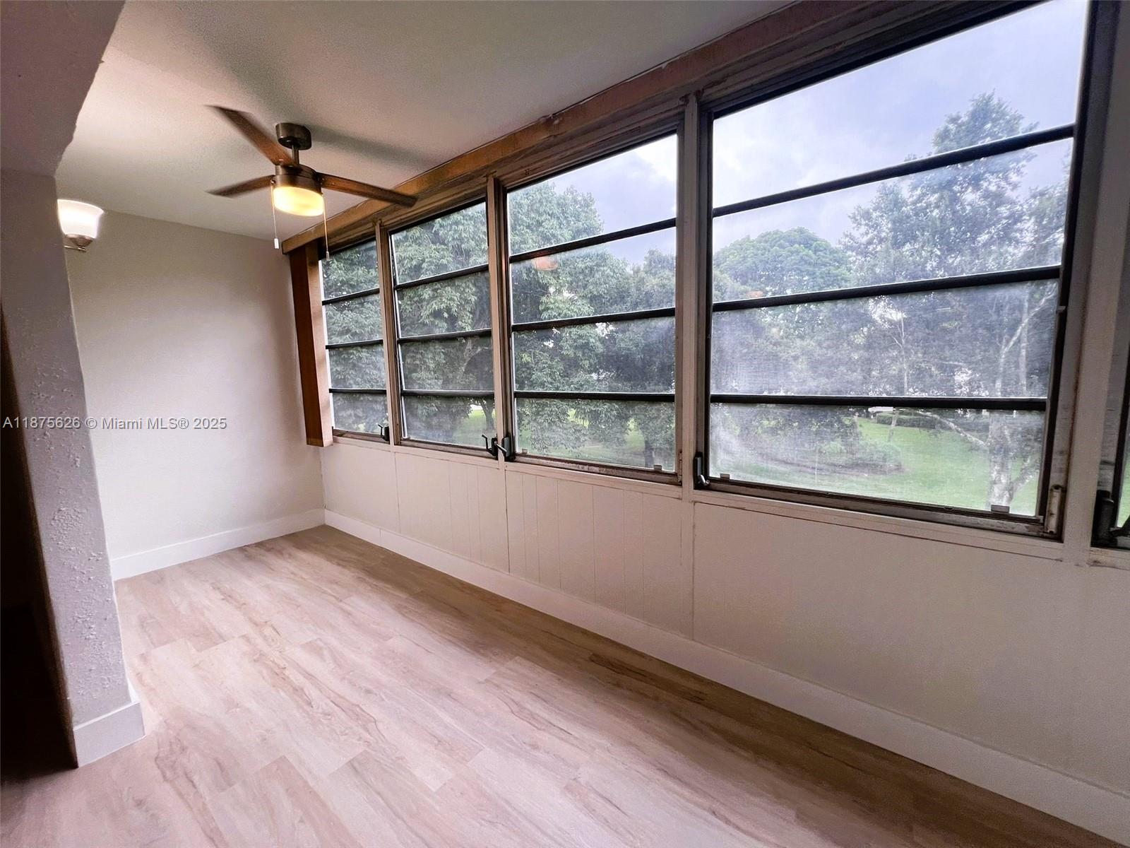 2002 Granada Drive, Unit J3 Coconut Creek, FL 33066 - Photo 15 of 24 an empty room with wooden floor and windows