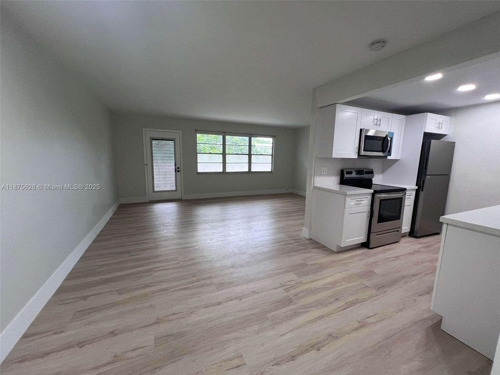 2002 Granada Drive, Unit J3 Coconut Creek, FL 33066 - Photo 4 of 24 a view of a kitchen with wooden floor and electronic appliances