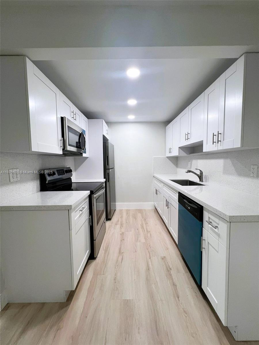 2002 Granada Drive, Unit J3 Coconut Creek, FL 33066 - Photo 5 of 24 a kitchen with stainless steel appliances granite countertop a stove a sink and a refrigerator