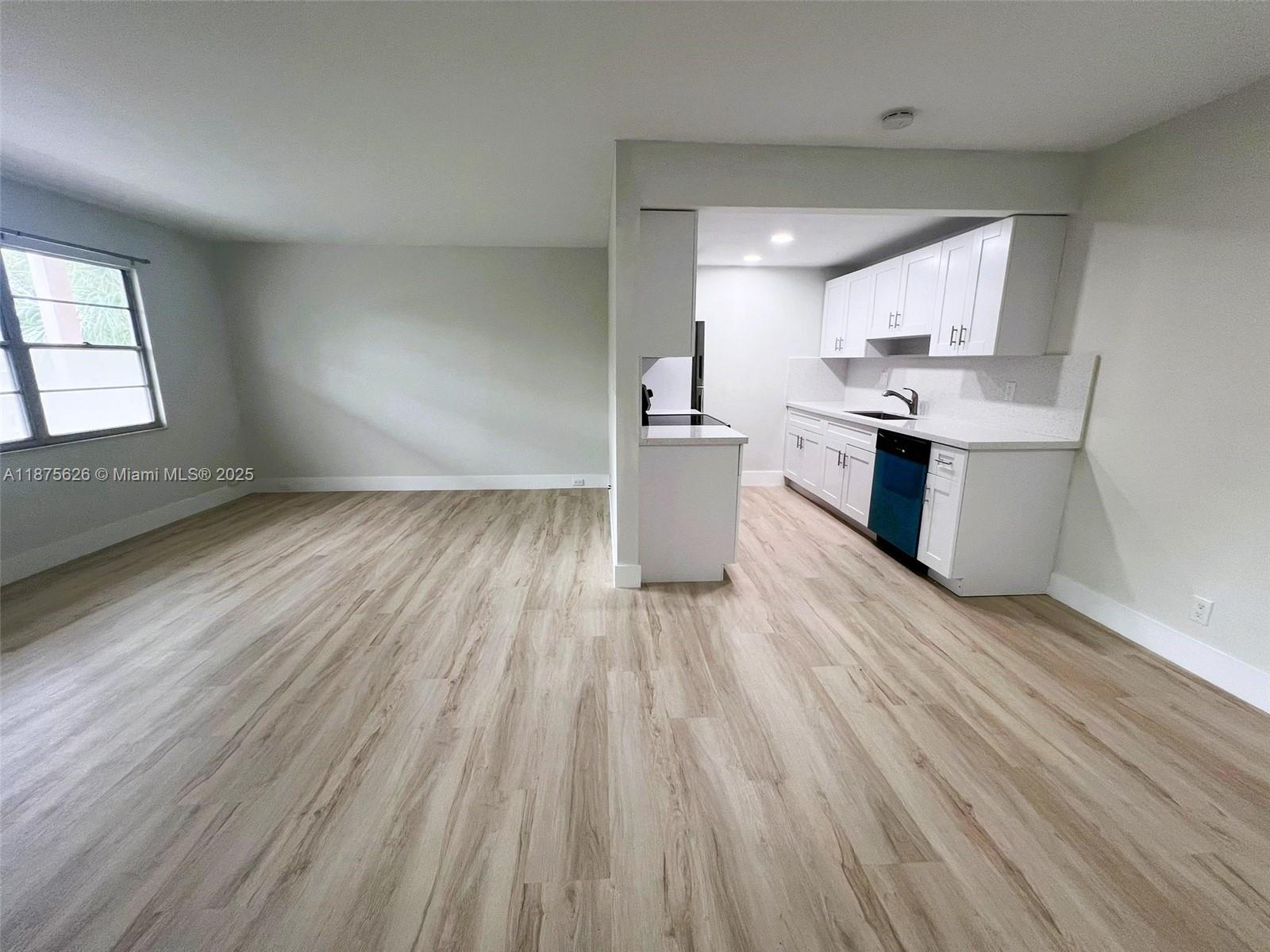 2002 Granada Drive, Unit J3 Coconut Creek, FL 33066 - Photo 6 of 24 a kitchen with a wooden floor and a sink