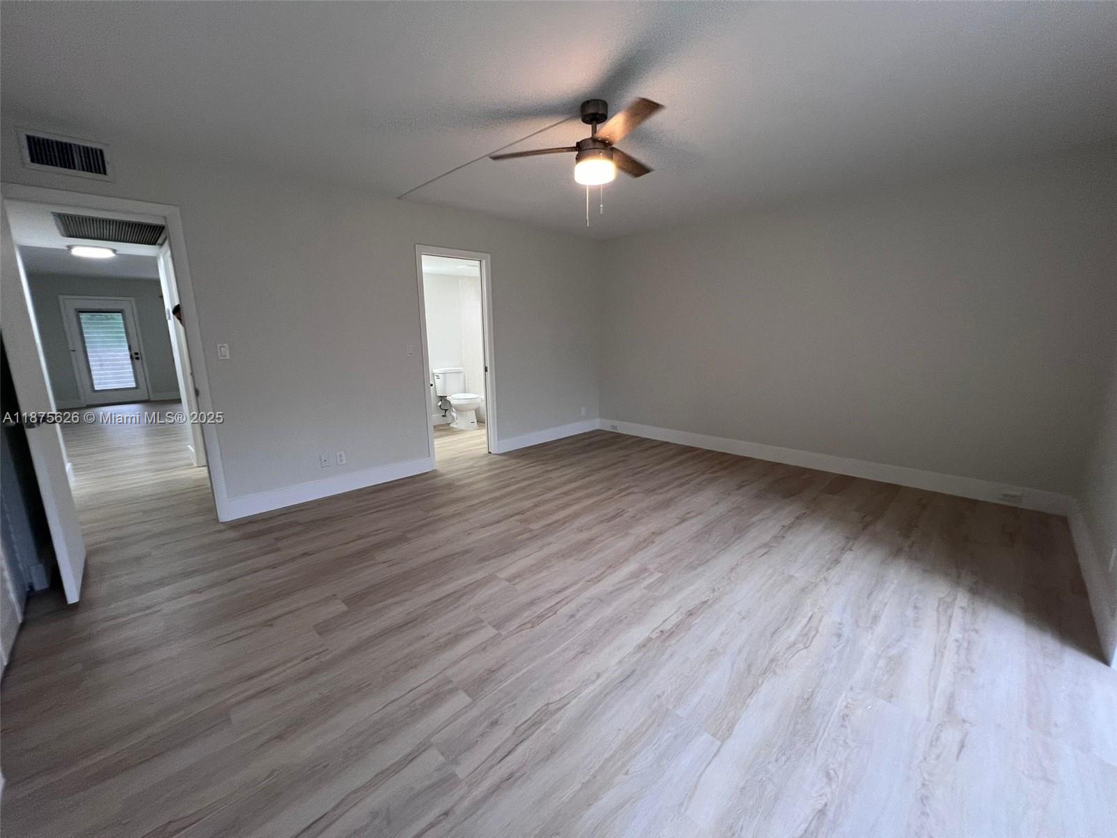2002 Granada Drive, Unit J3 Coconut Creek, FL 33066 - Photo 10 of 24 wooden floor in an empty room with a window