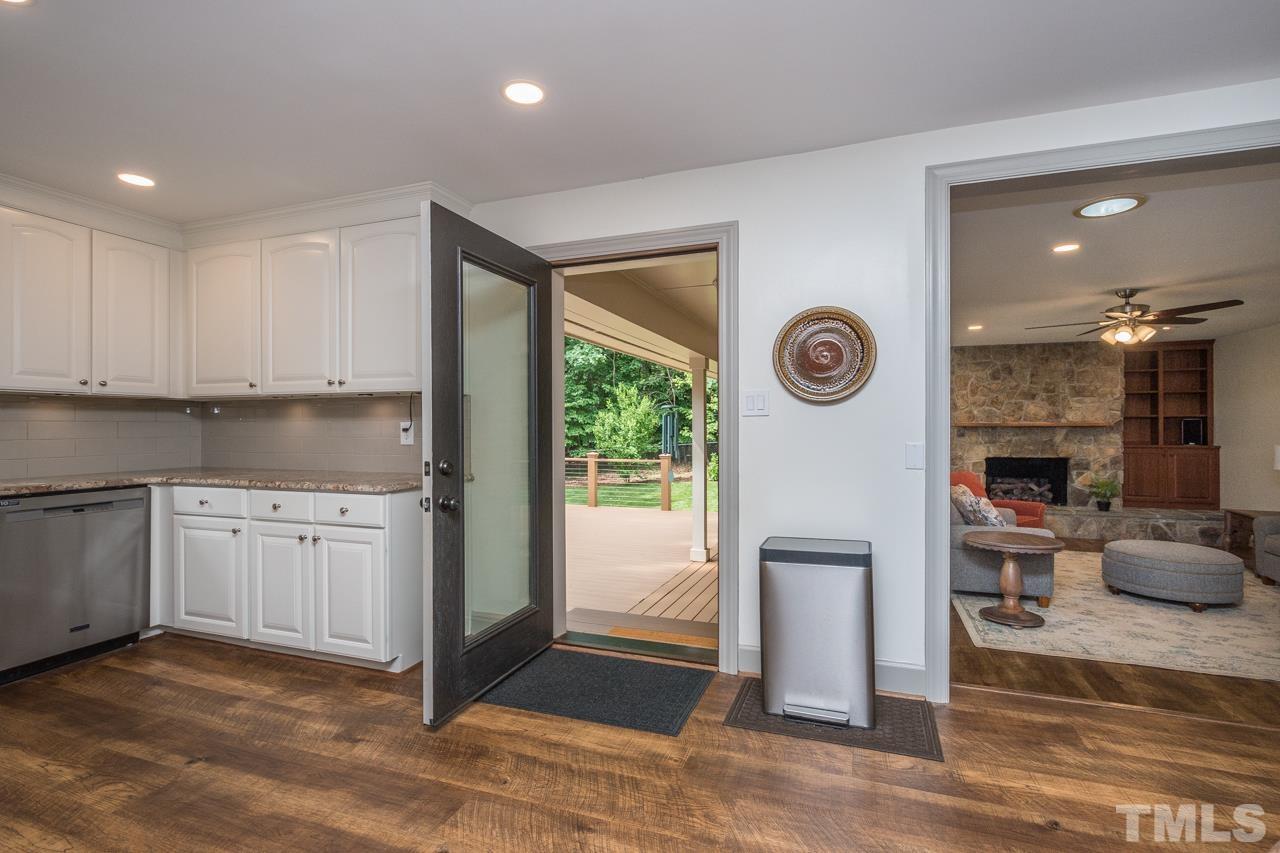 2505 Countrywood Road Raleigh, NC 27615 - Photo 12 of 36 a kitchen with stainless steel appliances granite countertop a refrigerator a stove and a sink with wooden floor