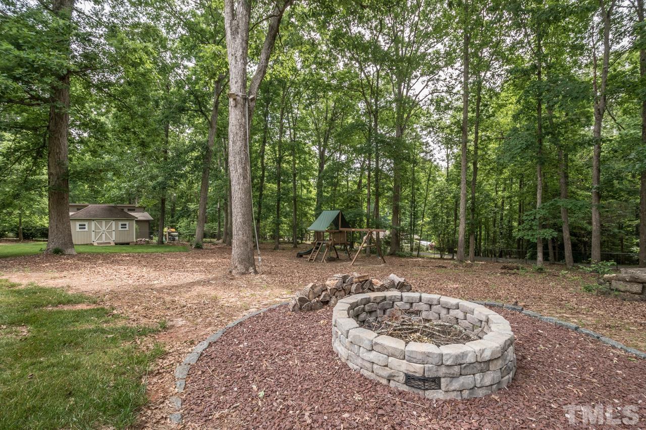 2505 Countrywood Road Raleigh, NC 27615 - Photo 16 of 36 a view of a backyard with a fountain and plants