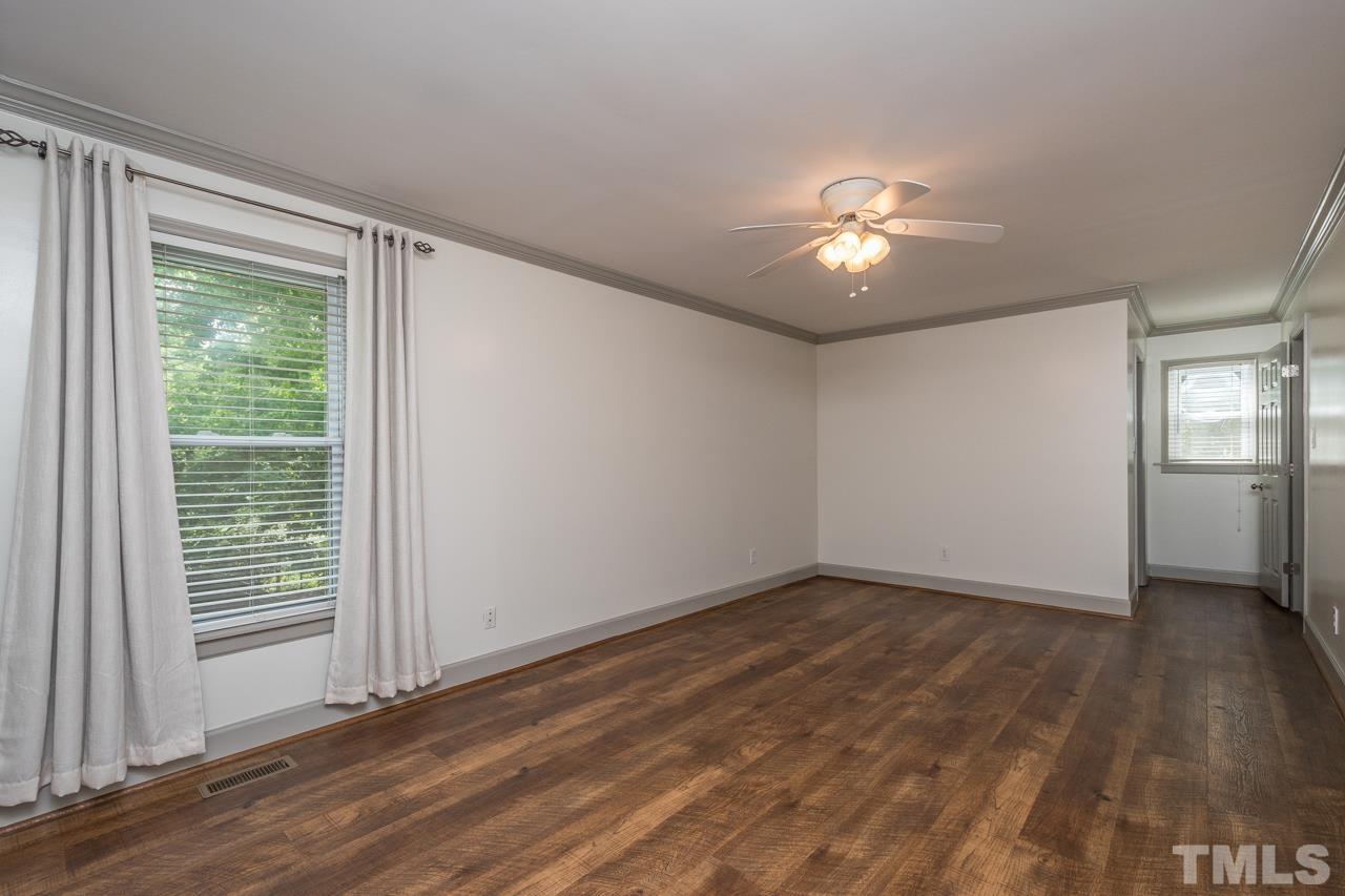 2505 Countrywood Road Raleigh, NC 27615 - Photo 23 of 36 a view of empty room with wooden floor and fan