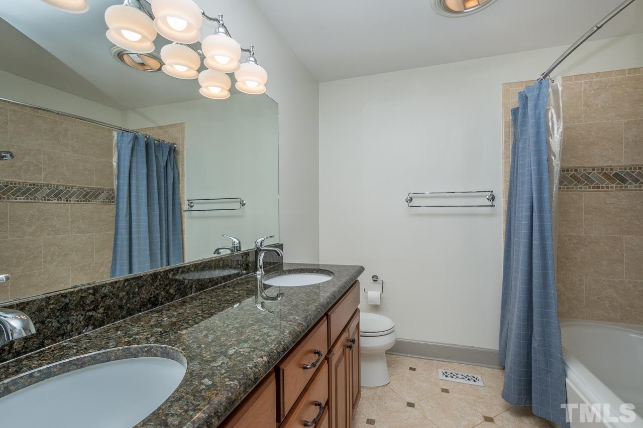 2505 Countrywood Road Raleigh, NC 27615 - Photo 29 of 36 a bathroom with a granite countertop sink a toilet and a mirror