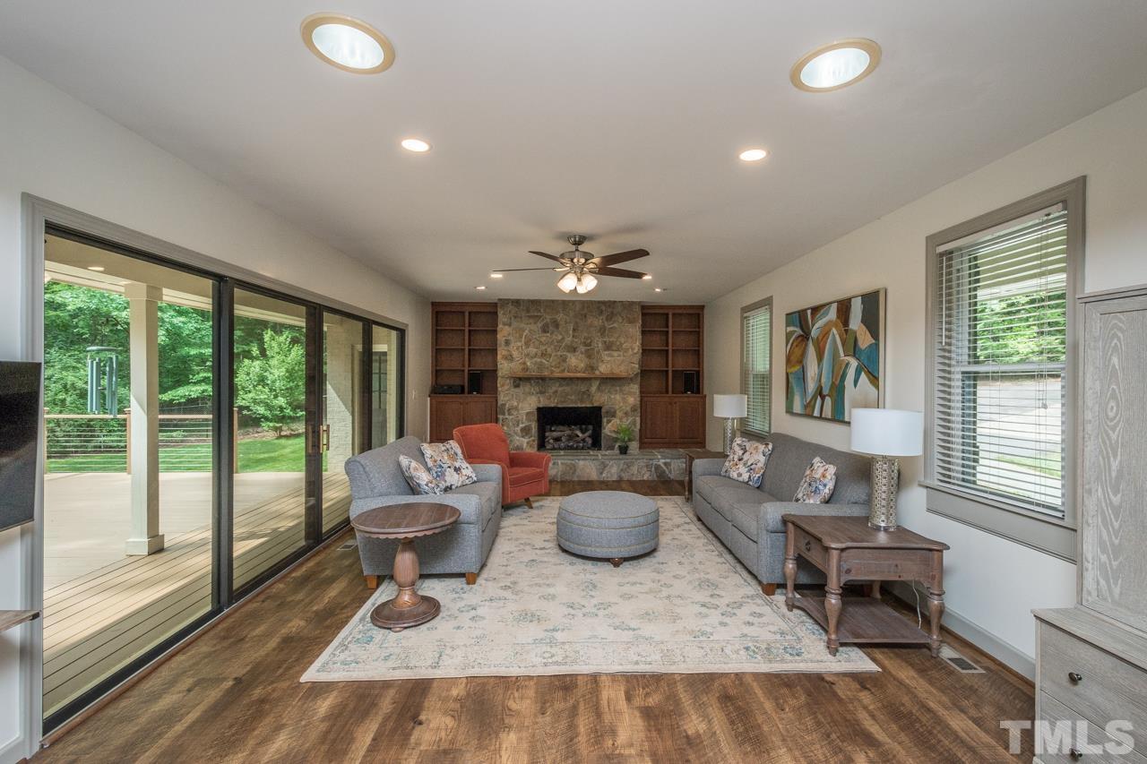2505 Countrywood Road Raleigh, NC 27615 - Photo 3 of 36 a living room with furniture a fireplace and a floor to ceiling window