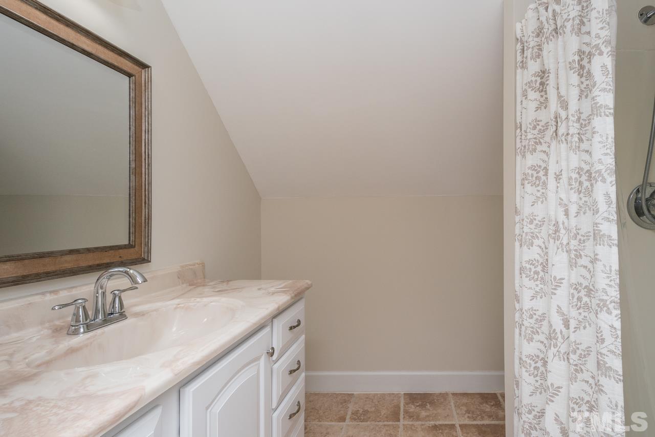 2505 Countrywood Road Raleigh, NC 27615 - Photo 34 of 36 a bathroom with a granite countertop sink and a mirror