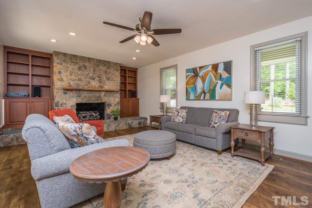 2505 Countrywood Road Raleigh, NC 27615 - Photo 5 of 36 a living room with furniture a fireplace and a flat screen tv