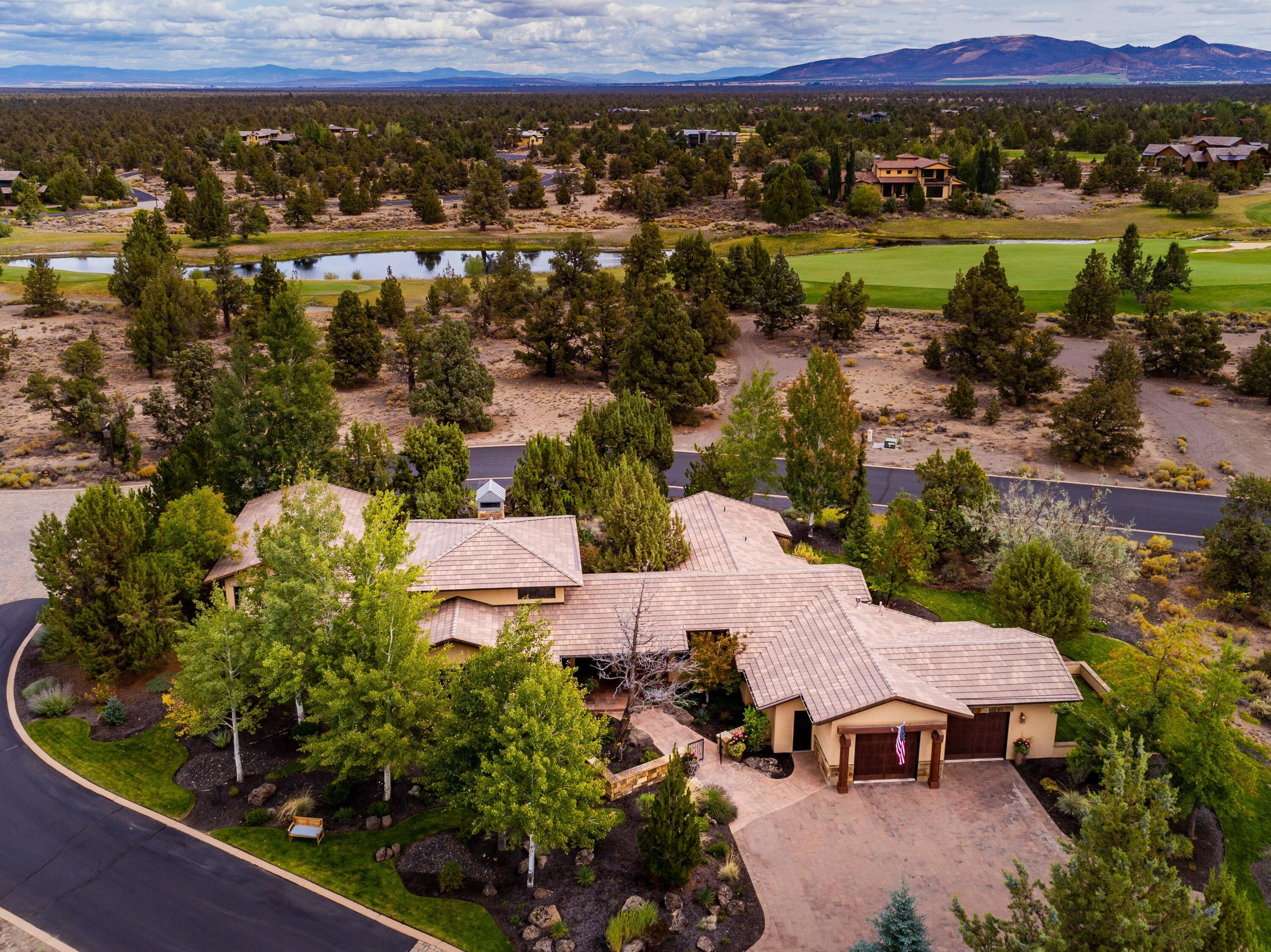 65904 Fazio Ln Bend Bend, OR 97701 - Photo 2 of 63 Situated on a quiet, .74/acre corner lot and surrounded by mature High Desert landscaping, lush gardens and peaceful water features.