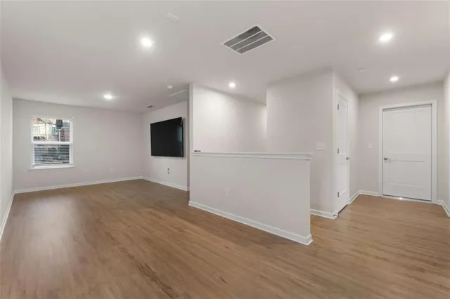 a view of a room with wooden floor and flat screen tv
