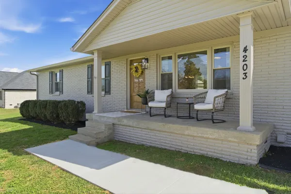 a view of a house with backyard and sitting area