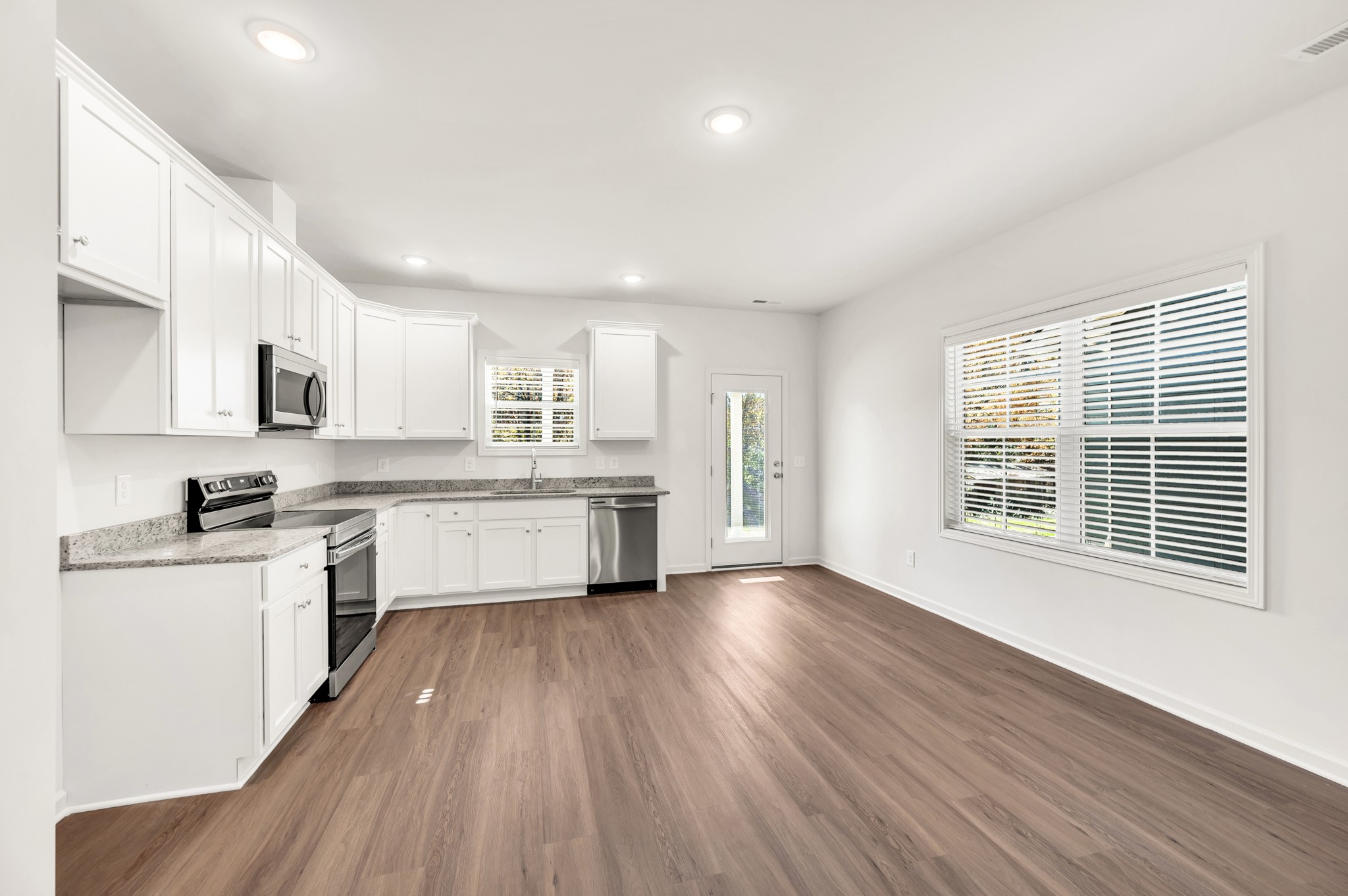 7103 Wiley Circle Fairview, TN 37062 - Photo 10 of 33 a large kitchen with stainless steel appliances granite countertop a stove a sink dishwasher a microwave oven with cabinets and wooden floor