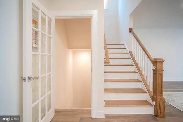 a view of staircase with wooden floor and white walls