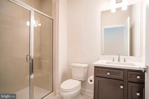a bathroom with a toilet a sink a mirror and vanity