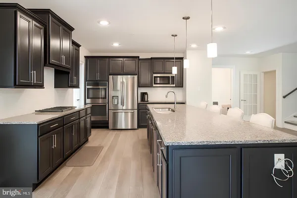 a kitchen with granite countertop a sink a counter top stainless steel appliances and cabinets