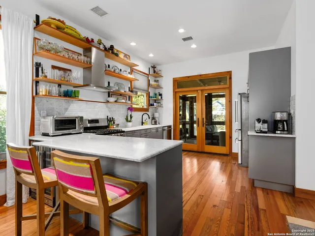 a open kitchen with stainless steel appliances granite countertop a stove and a refrigerator