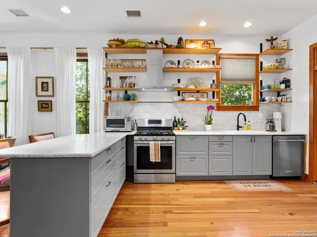 a kitchen with stainless steel appliances granite countertop a sink and cabinets