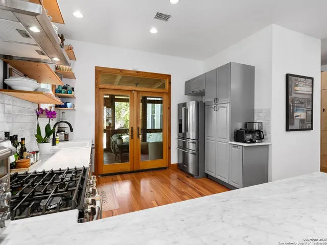 a kitchen with stainless steel appliances kitchen island granite countertop a refrigerator and a sink