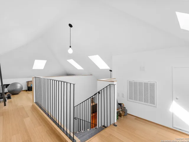 a view of a livingroom with a flesh screen tv and stairs